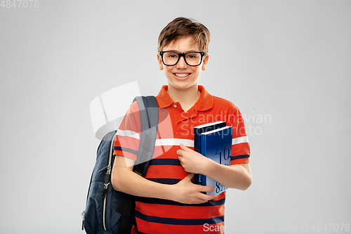 Image of smiling student boy with backpack and books