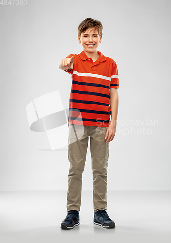 Image of portrait of smiling boy pointing finger to camera