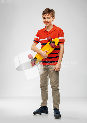 Image of smiling boy with short skateboard