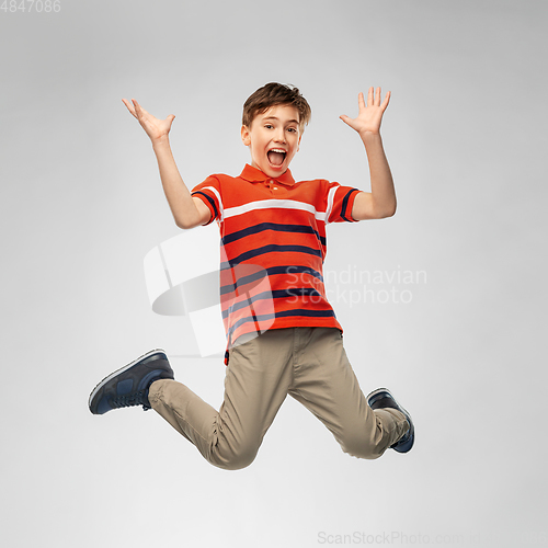 Image of happy smiling young boy jumping in air