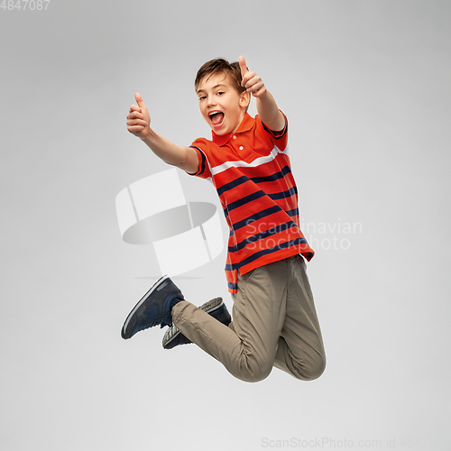 Image of happy smiling young boy jumping in air