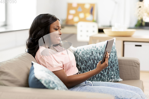 Image of african american woman with tablet pc at home