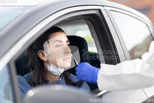 Image of healthcare worker making coronavirus test at car