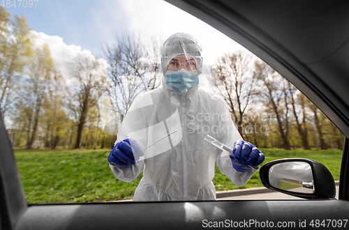 Image of healthcare worker making coronavirus test at car