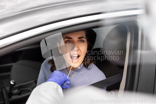 Image of healthcare worker making coronavirus test at car