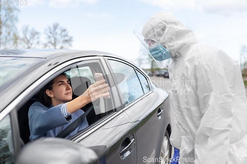 Image of woman in car showing phohe to healthcare worker