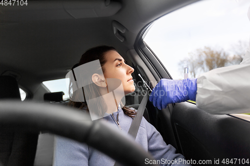 Image of healthcare worker making coronavirus test at car