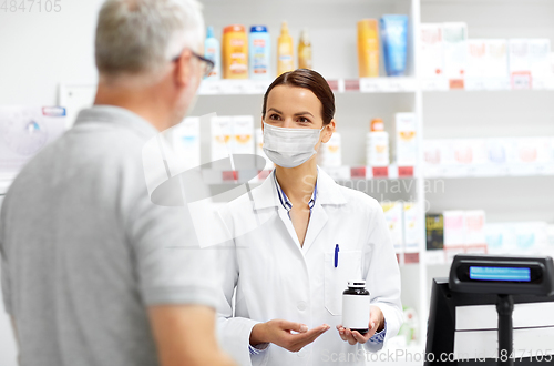 Image of apothecary in mask and senior customer at pharmacy