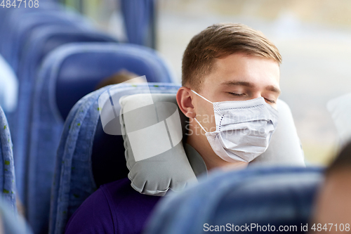 Image of man in mask sleeping in travel bus with pillow