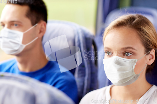 Image of young woman in mask sitting in travel bus or train