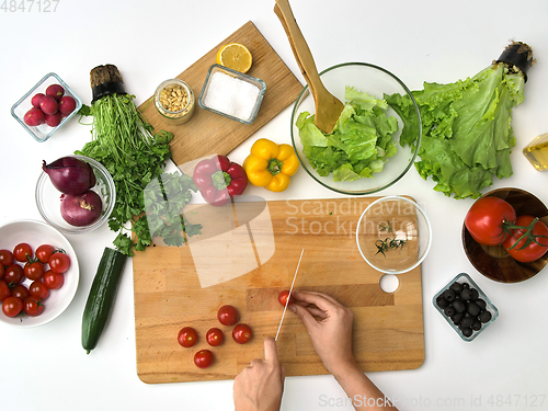 Image of woman chopping tomato with knife at kitchen