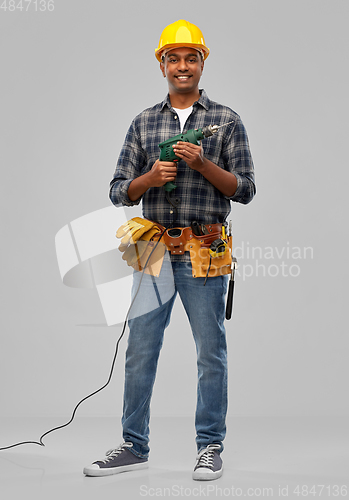 Image of happy indian builder in helmet with electric drill