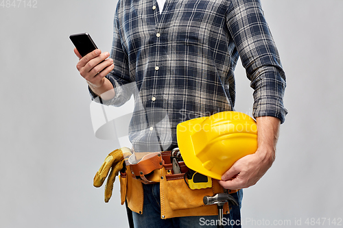 Image of worker or builder with phone and working tools