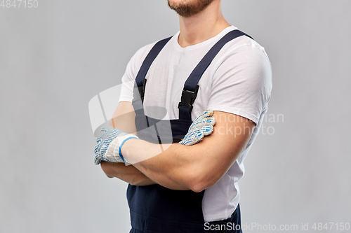 Image of close up of male builder in overall and gloves