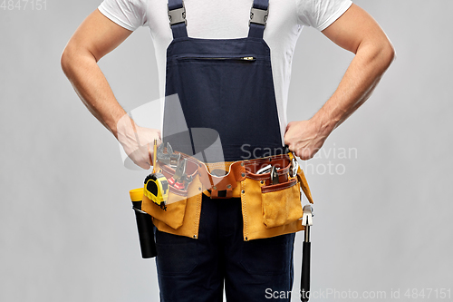 Image of worker or builder in overall with working tools