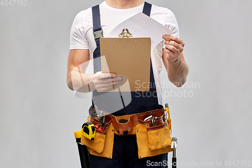 Image of builder with clipboard, pencil and working tools