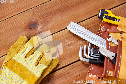 Image of different work tools in belt on wooden boards