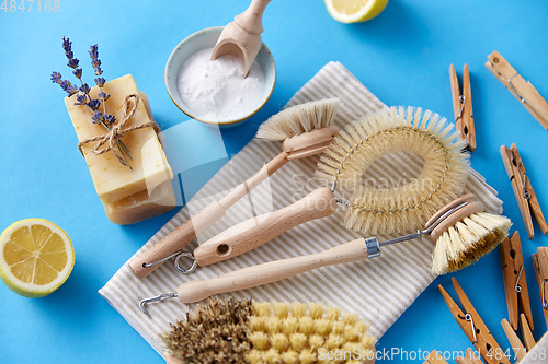 Image of cleaning brushes, lemon and wooden clothespins