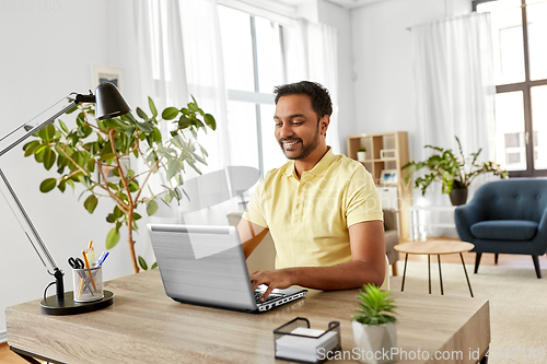 Image of indian man with laptop working at home office