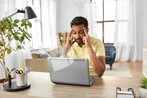 Image of indian man with laptop working at home office