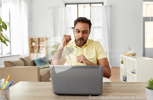 Image of indian man with laptop working at home office