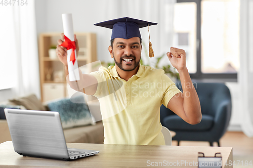 Image of indian student with laptop and diploma at home