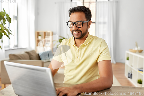 Image of indian man with laptop working at home office