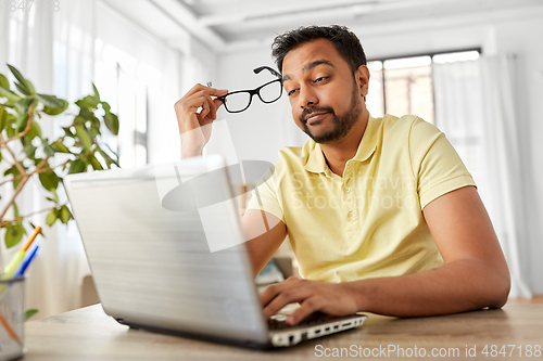Image of stressed man with laptop working at home office