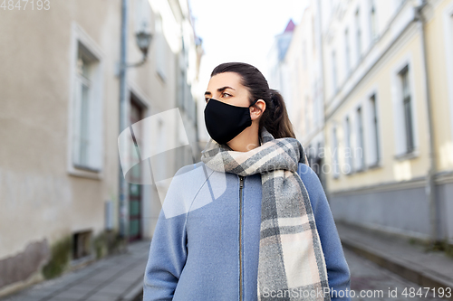 Image of woman wearing protective reusable mask in city