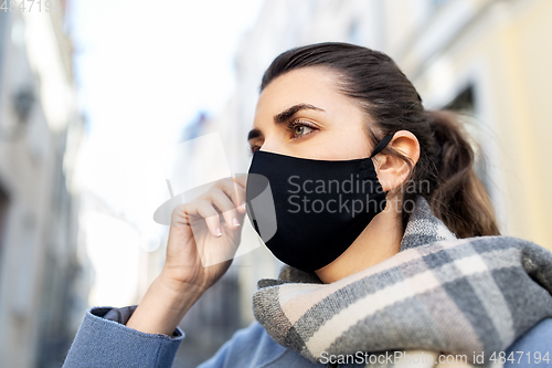 Image of woman wearing protective reusable mask in city