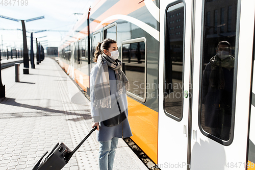 Image of woman in protective face mask at railway station