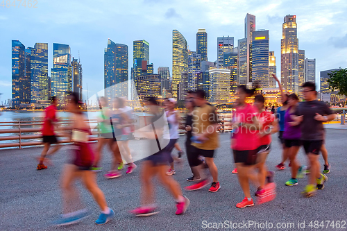 Image of Joggers on illuminated Singapore promenade