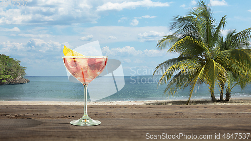 Image of Summer refreshing cocktail with sea or ocean beach on background