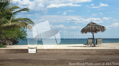 Image of Glass of cold mineral water on the table of the beach background