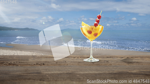 Image of Summer refreshing cocktail with sea or ocean beach on background