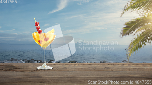 Image of Summer refreshing cocktail with sea or ocean beach on background