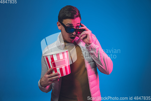 Image of Caucasian man\'s portrait isolated on blue studio background in neon light