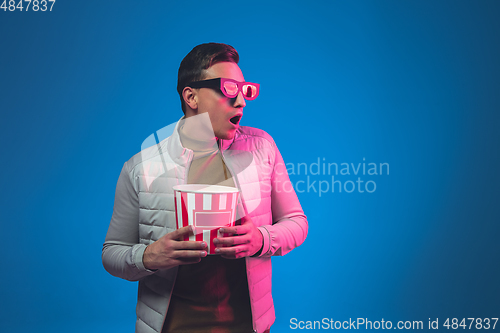 Image of Caucasian man\'s portrait isolated on blue studio background in neon light