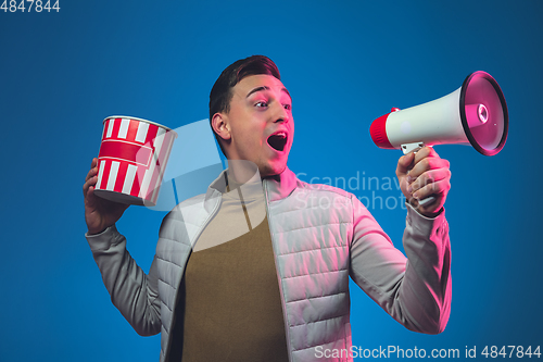 Image of Caucasian man\'s portrait isolated on blue studio background in neon light