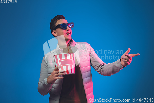 Image of Caucasian man\'s portrait isolated on blue studio background in neon light