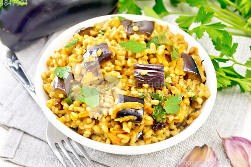 Image of Bulgur with eggplant in bowl on board