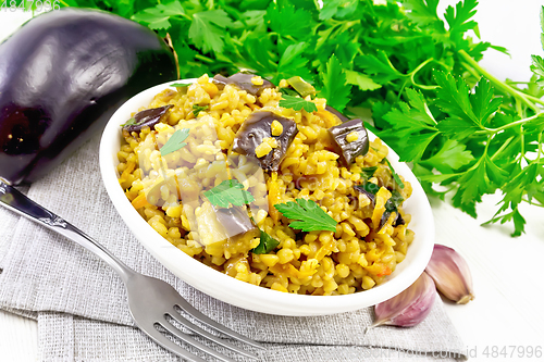 Image of Bulgur with eggplant in bowl on light board