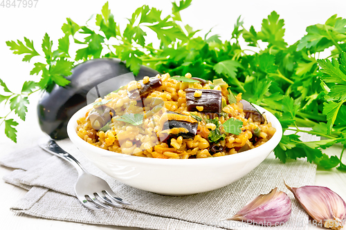 Image of Bulgur with eggplant in bowl on wooden board