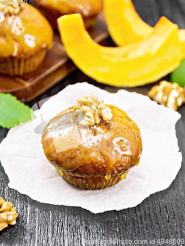 Image of Cupcake pumpkin with orange glaze and walnuts on paper