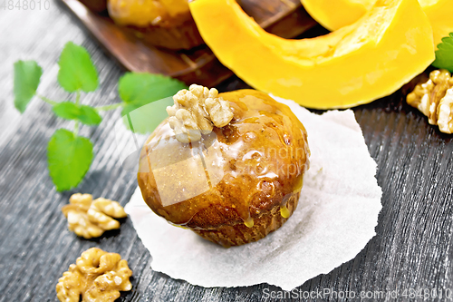 Image of Cupcake pumpkin with orange glaze and walnuts on parchment