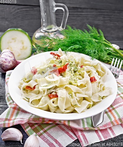 Image of Fettuccine with zucchini and hot peppers in plate on black board