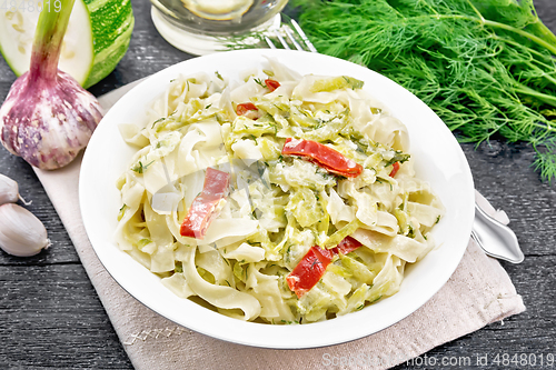 Image of Fettuccine with zucchini and hot peppers in plate on napkin