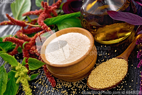 Image of Flour amaranth in bowl and oil on wooden board