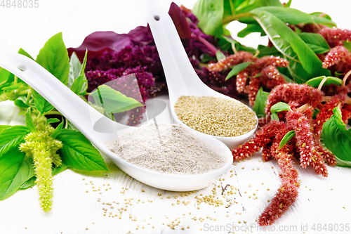 Image of Flour and seeds amaranth in spoons on wooden board