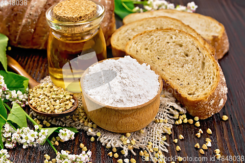 Image of Flour buckwheat green in bowl with bread on dark board